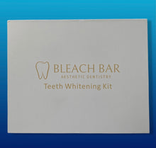 Load image into Gallery viewer, High quality gift box for teeth whitening kit. Includes 3 gel pens with whitening agent, 1 desensitizing gel pen, rechargeable LED light with charger. Bleach bar logo in sand color on white box with blue gradient background
